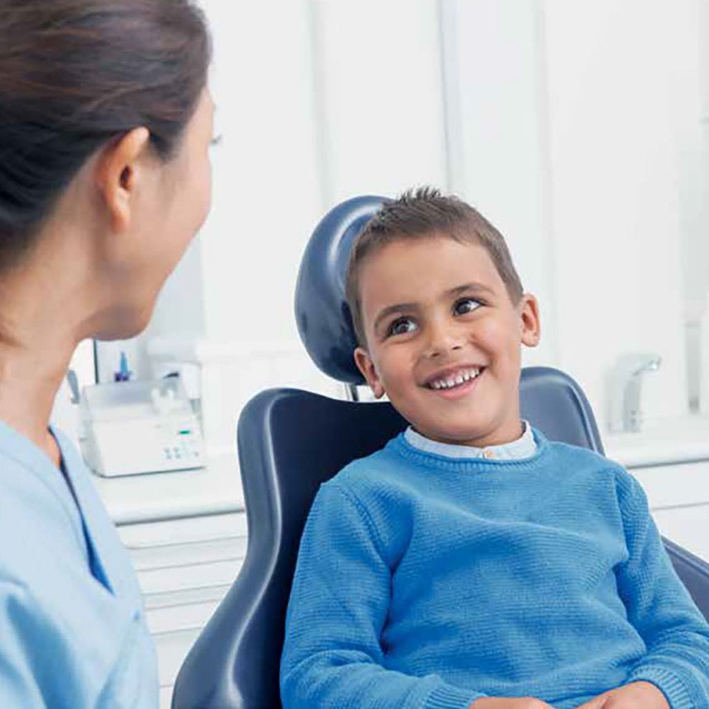 smiling boy in dentist chair