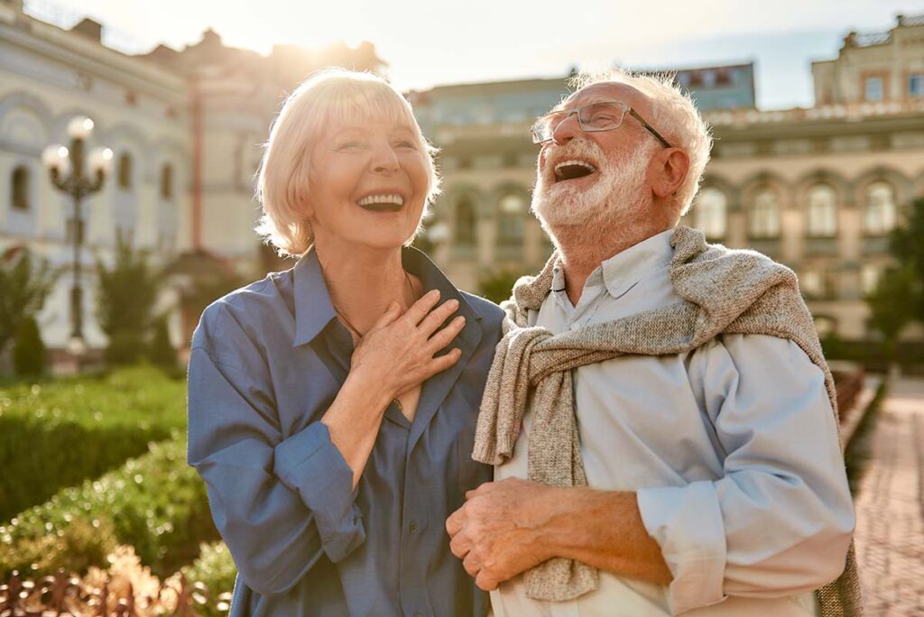 A senior couple laughing & smiling after addressing dental concerns at the dental office to improve breathing
